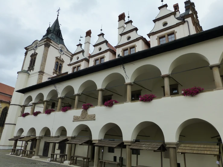 the building has arches and arched windows with flower boxes