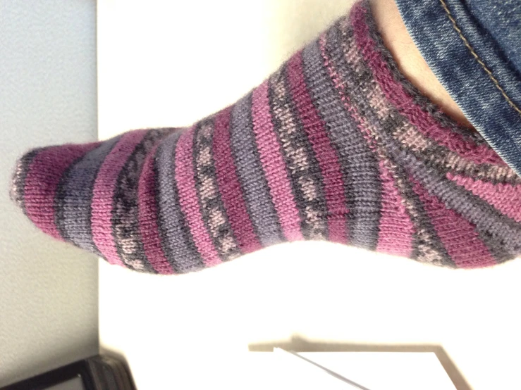 the lower half of a person's feet with striped socks