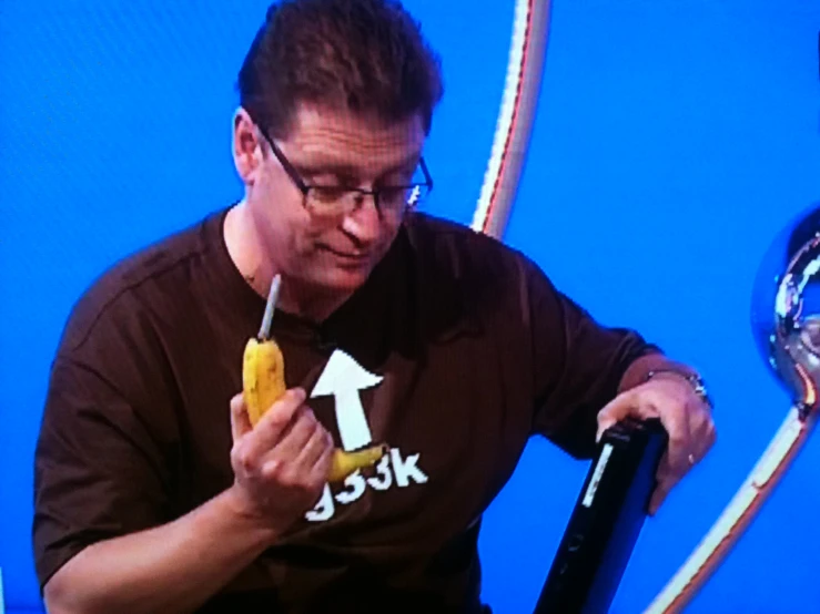 a man holding a banana while looking at it