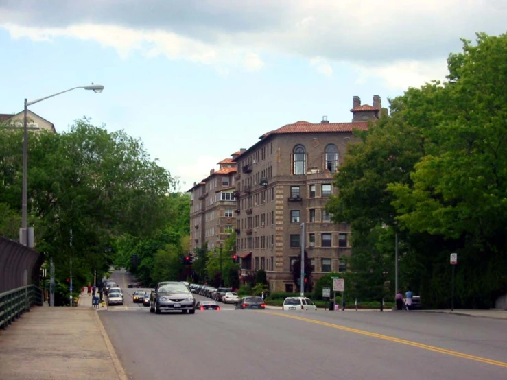 a street full of cars next to a large brown building