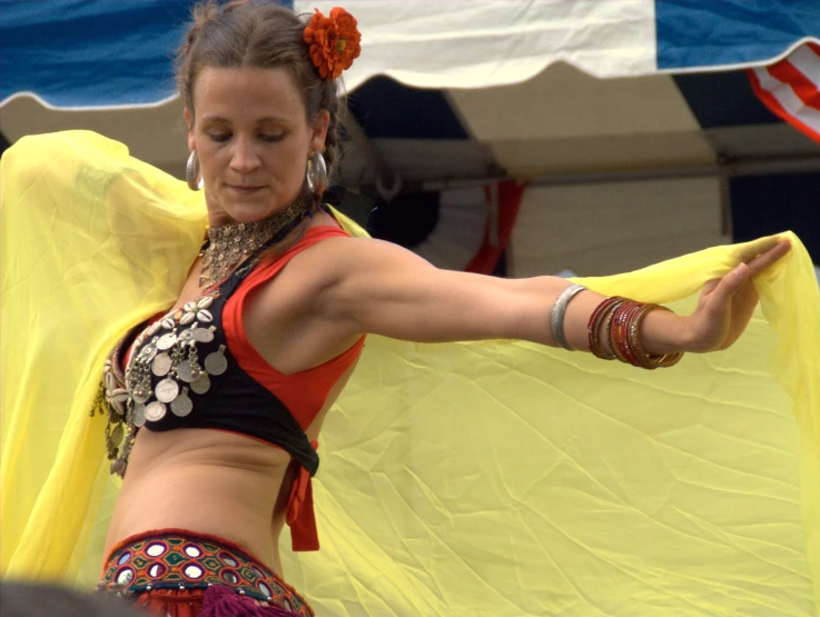 a woman in a bikini top dancing with her hands behind her head