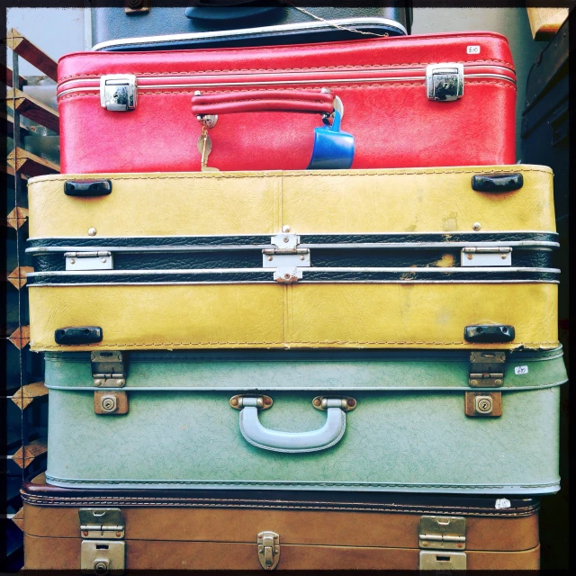 there are four old and new suitcases stacked on top of each other
