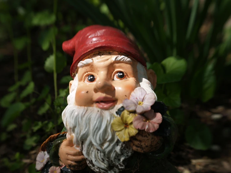 a gnome with flowers around his neck is sitting in a garden
