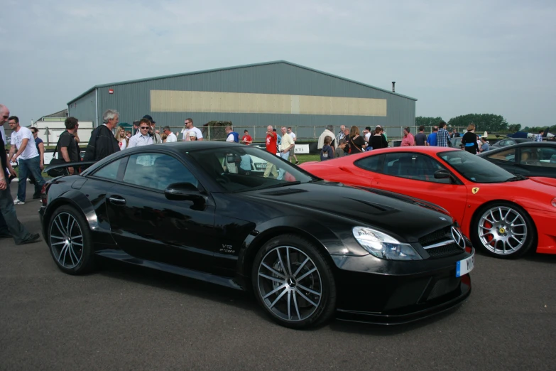 a car and people in front of a building with a few cars in the background