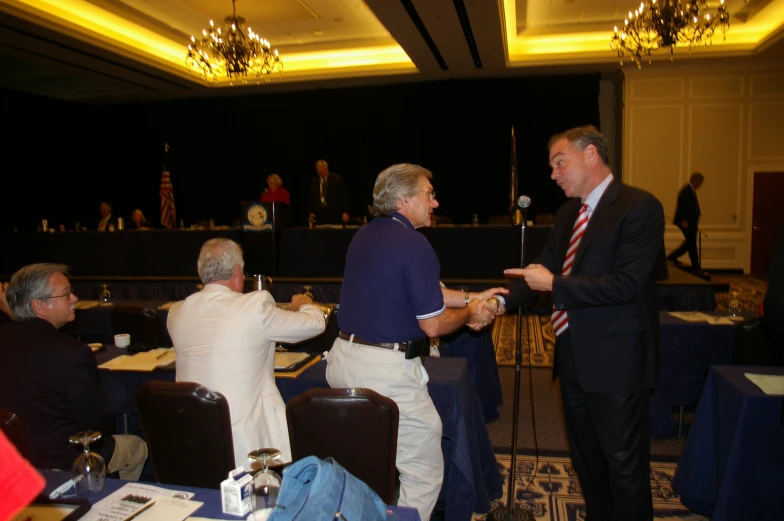 two men in a conference are speaking to an audience