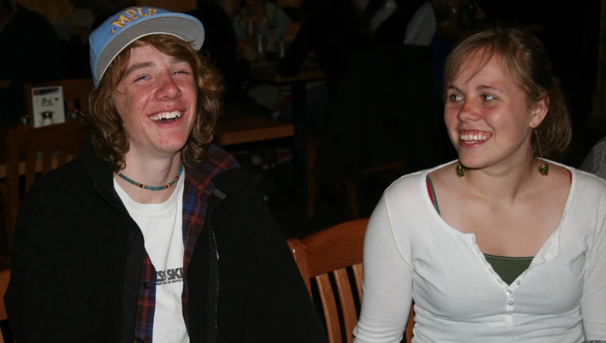 two young men and women are laughing for the camera