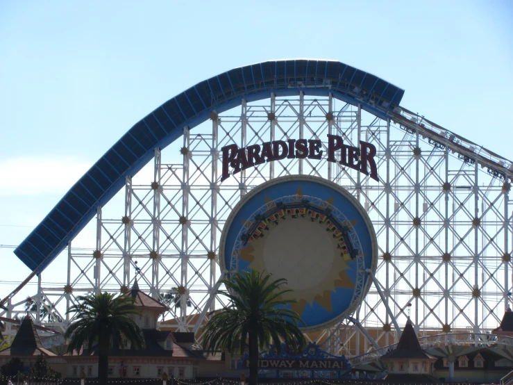 a sign that says paradise pier in front of the top of an amut park