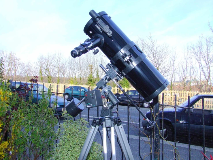 telescope in on the ground near a fence