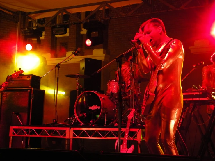 a woman in gold is standing on stage holding her microphone