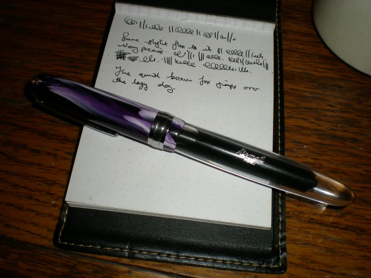 an open notepad with a pen sitting on top of it