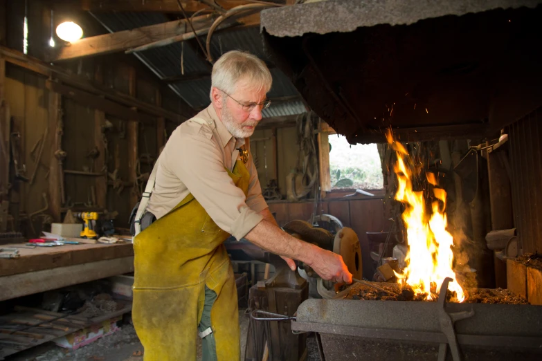 a man using an old fashioned stove to cook food