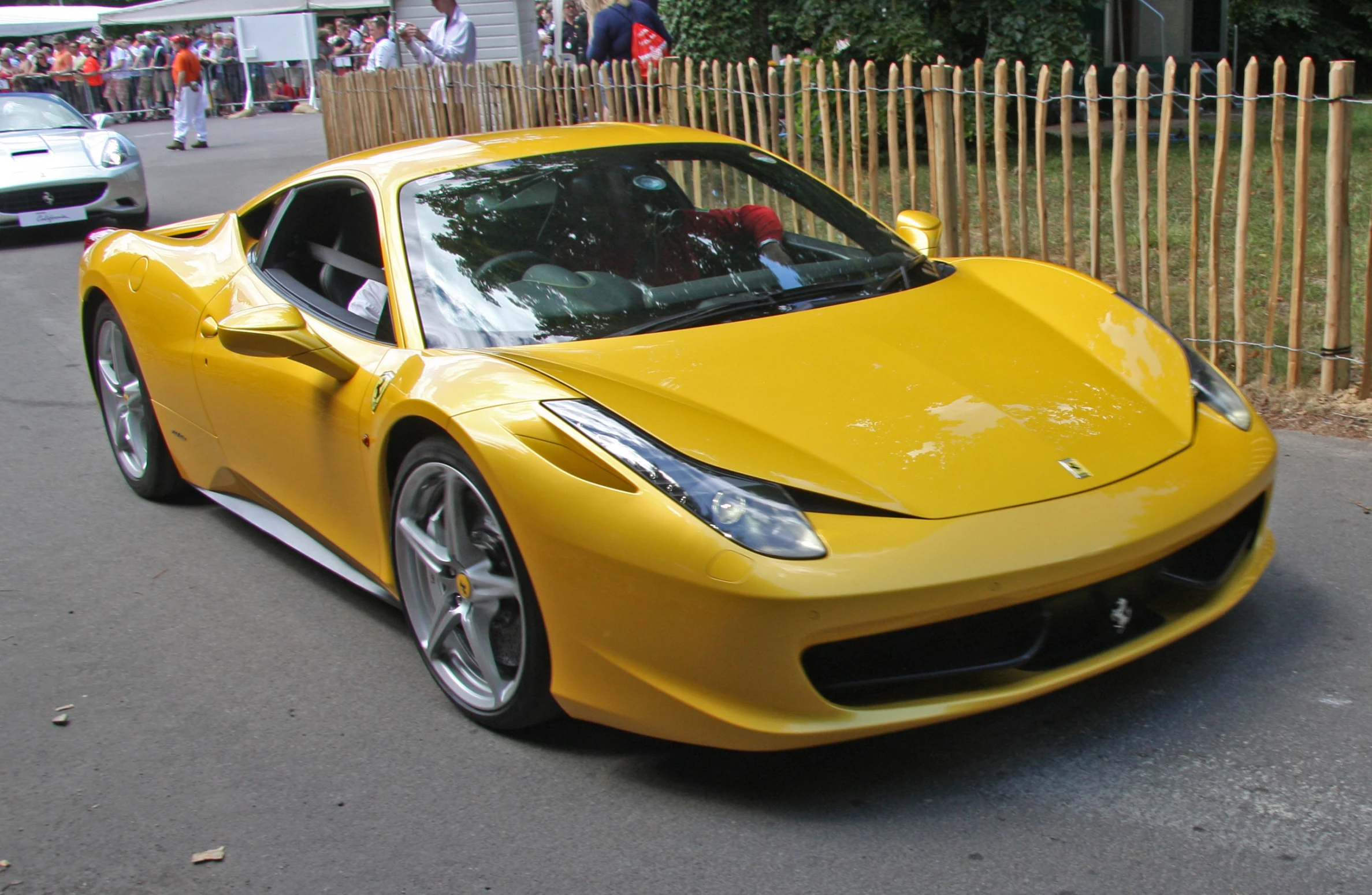 a yellow ferrari is going down the road