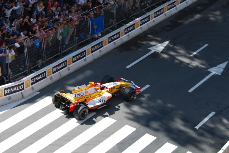 a man drives his car in front of a large crowd