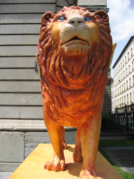 a statue of a lion stands in front of a building