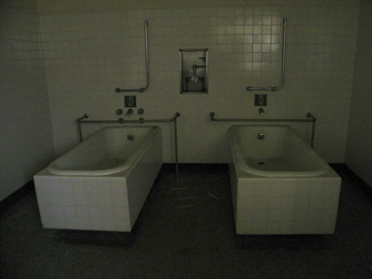 two white bath tubs sitting next to each other in a bathroom