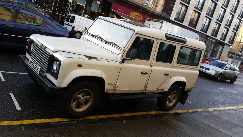 a white land rover on the side of the street