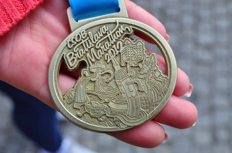 a person is holding a medal with a blue ribbon