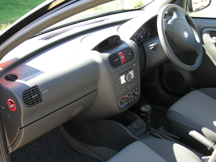 a small grey car with an interior sitting on the street