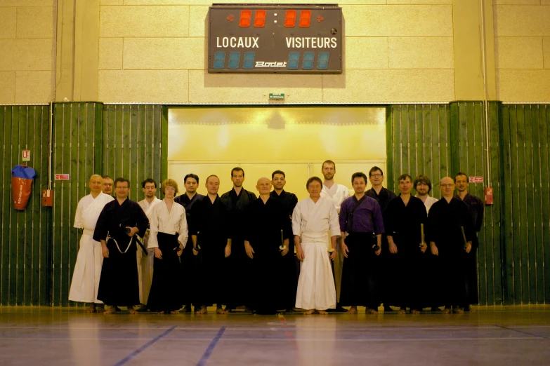 a group po of men in black standing on a gym