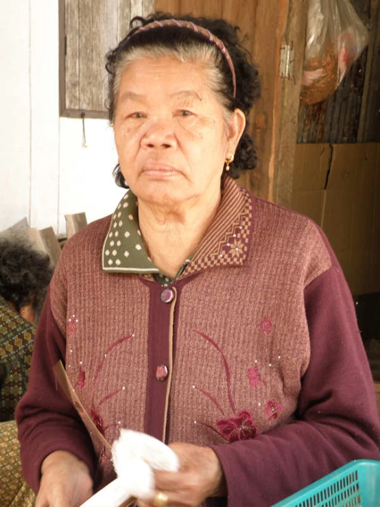 an older woman holding a piece of white paper
