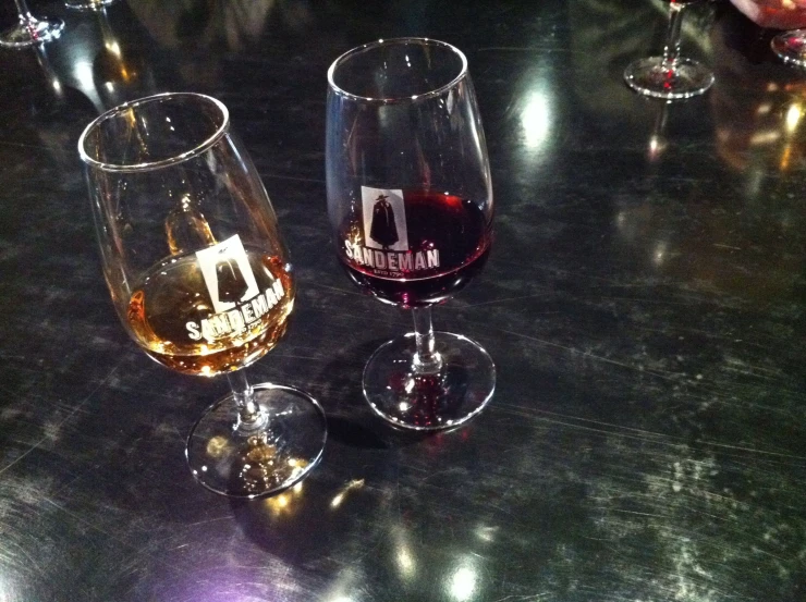 three wine glasses that have various types of wines inside of them
