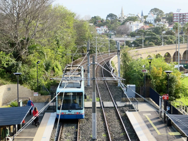 a blue and white train pulling into a station