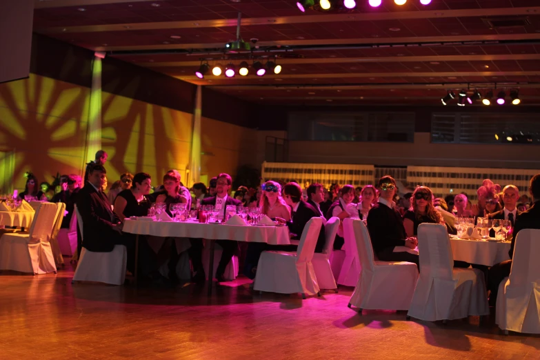 a room full of people sitting at tables