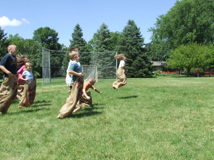 a group of people walking across a lush green field