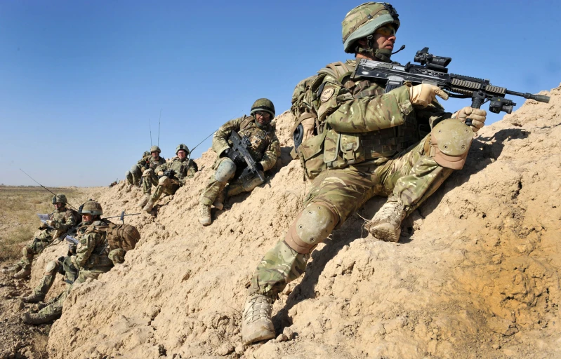 military men in the sand, with guns