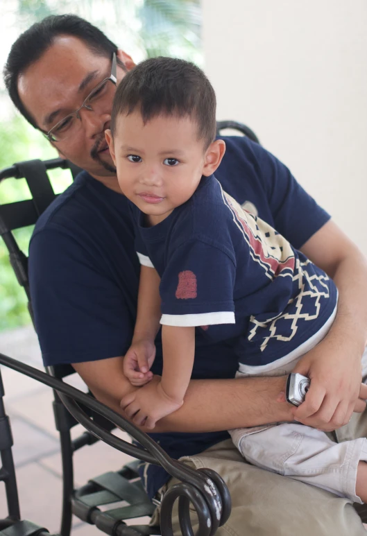 a young child is being held by his father