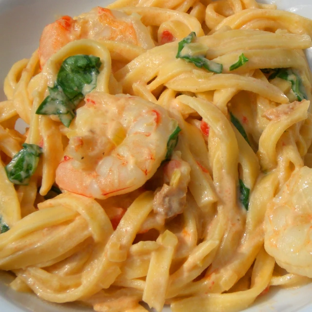 a white bowl filled with shrimp and pasta