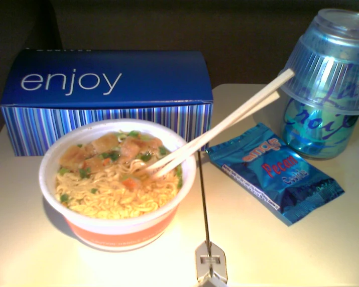 a bowl of ramen with chopsticks and water