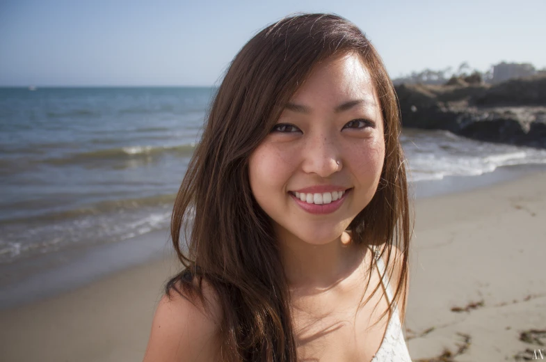 there is a woman smiling on the beach