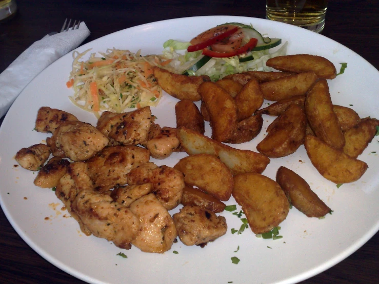 a plate with several pieces of chicken and side dishes on it