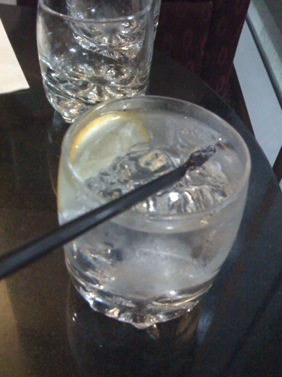 a large glass of ice water with some lemon wedges