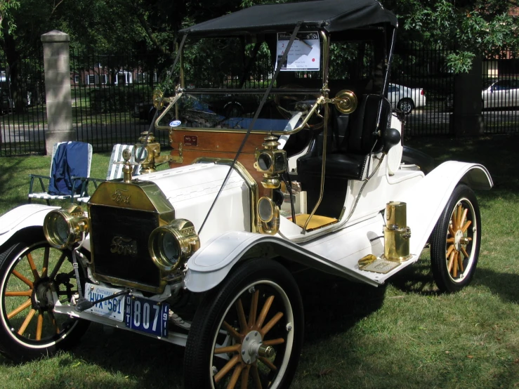 an old model car is parked on the lawn