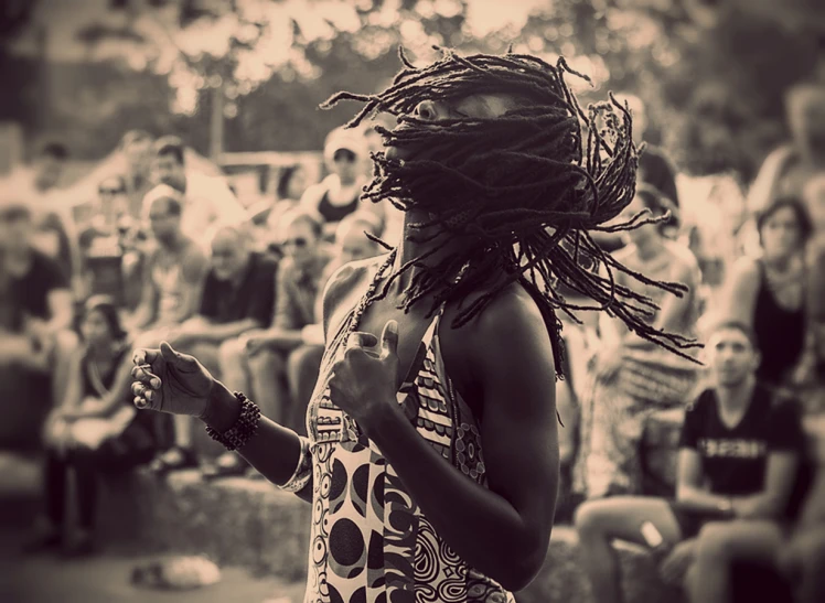 a woman standing next to a crowd with an instrument