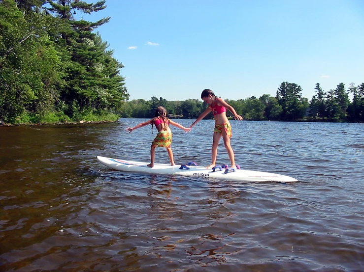 a couple of people that are on a surfboard