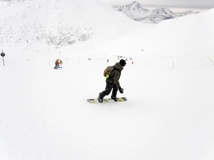 two men riding snowboards down a mountain side