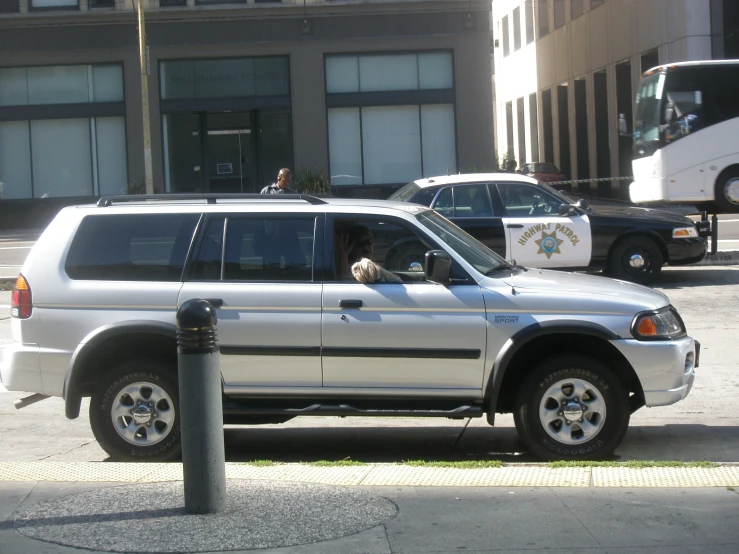 a police car sitting on a sidewalk in front of buildings