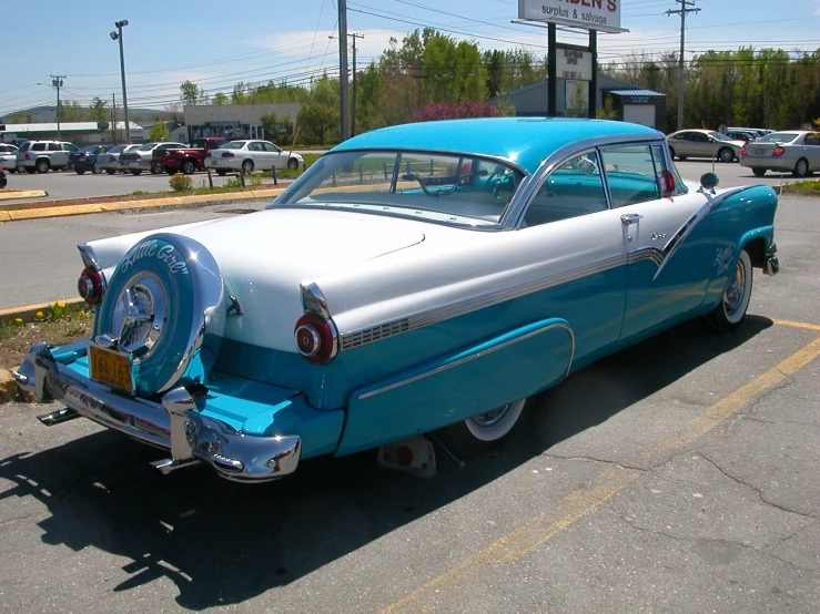 a classic car sits parked in a parking lot