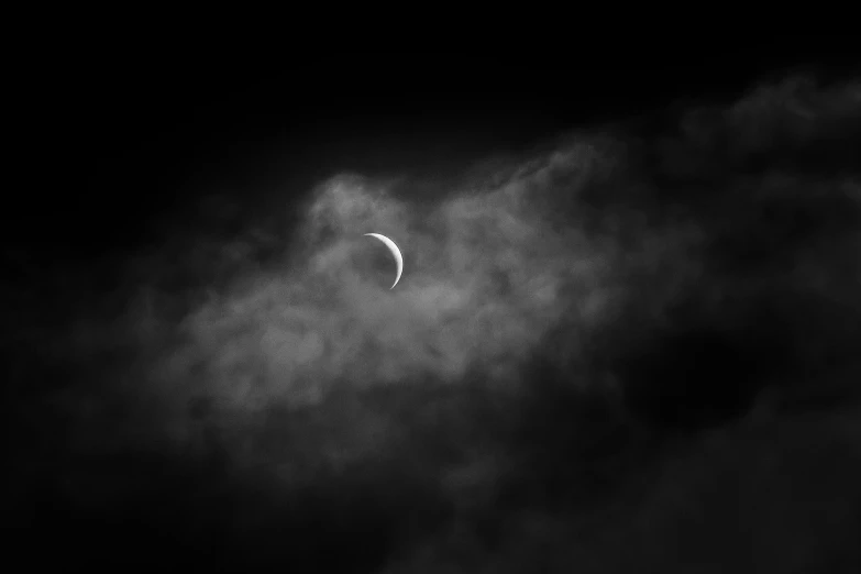 an eclipse in the sky behind a cloud