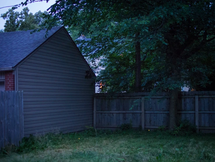 a dark gray house next to a fence