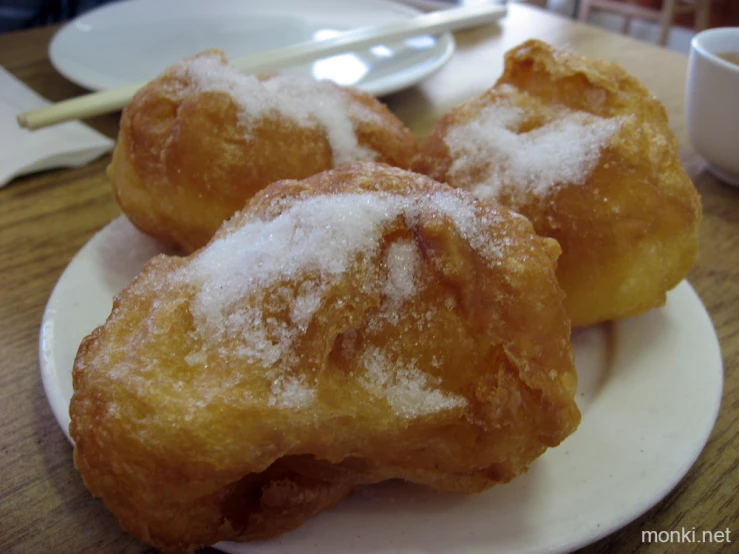 three sugar coated doughnuts on a plate