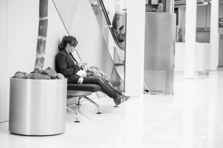 a woman with legs apart sitting in an airport