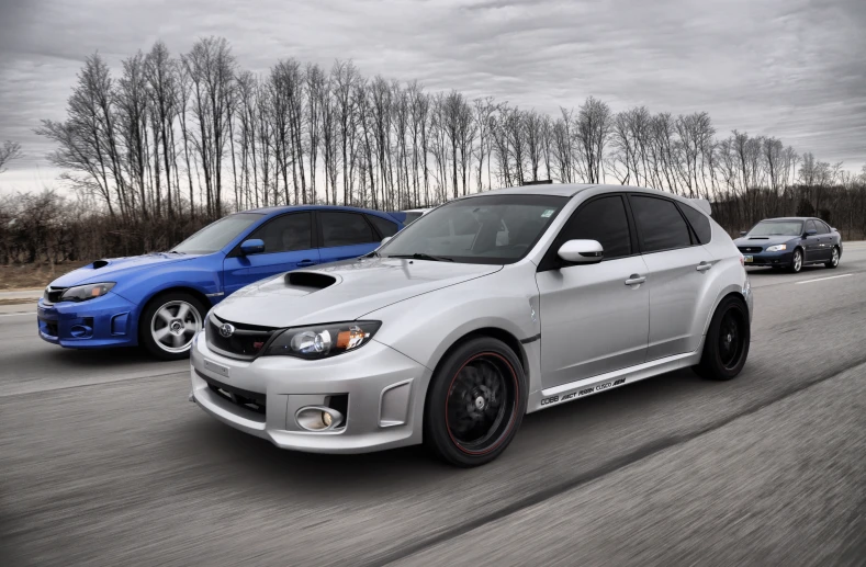 two cars one is silver, the other white and red