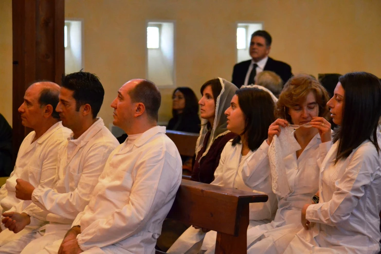 there are several people sitting in a pew at this church