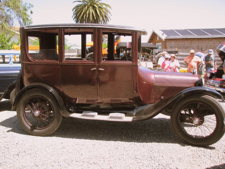 an old fashion car in a show with people around it