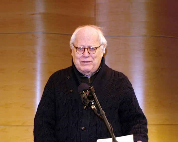 a man giving a speech in front of a microphone