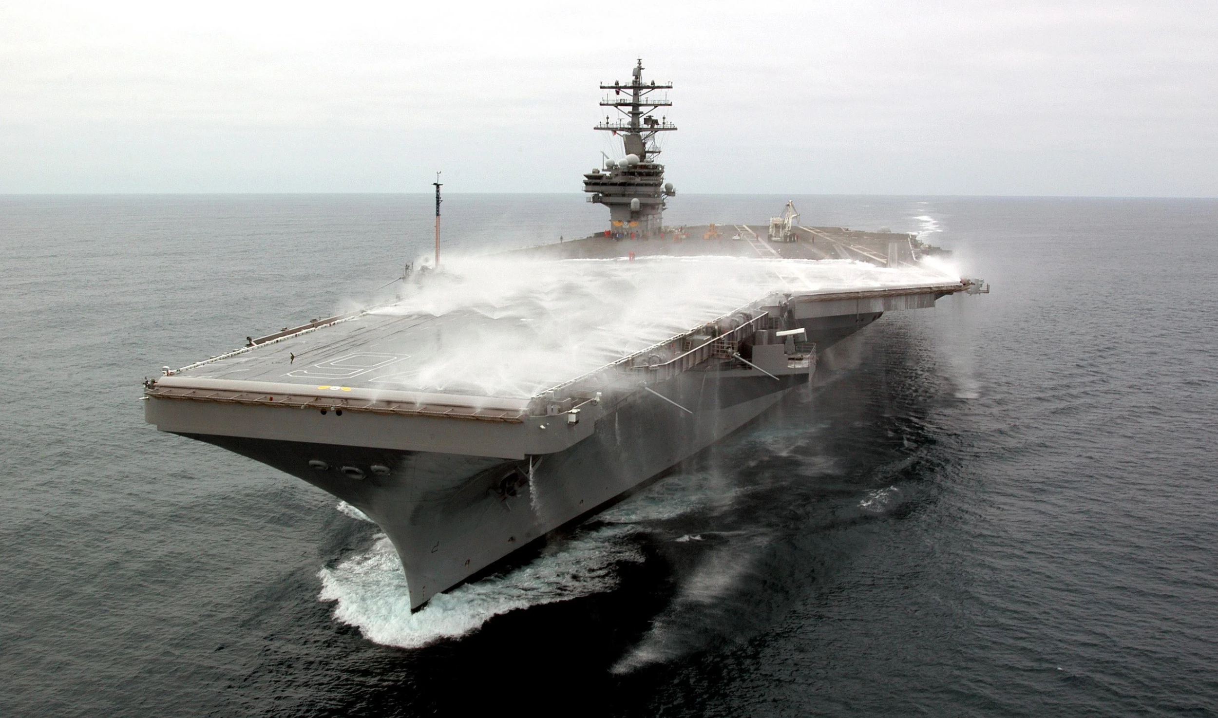 a large navy ship riding in the ocean